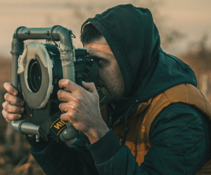 Photographer holding a camera outdoors.